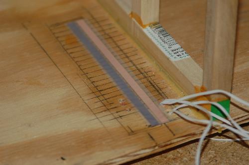 Sept12.JPG - Laying the tape wire. This acts as a socket for the round wires. I've laid the tape wire under the planned back staircase so that when I attach the staircase it will be covered. I'll find a way to temporarily attach the staircase for access. Probably with velcro.