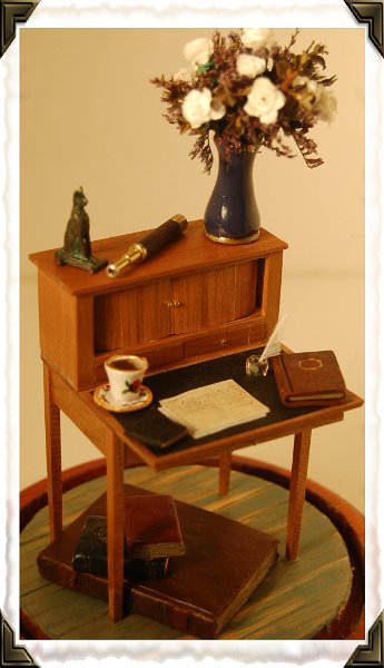 margarets_desk.jpg - This desk was made in a workshop at the last Tom Bishop show. It is a Martha Washington style desk.  I dressed it as Margaret Dashwood's desk with her papers, books (including the famous Atlas) and her telescope. This desk currently resides under a glass dome on my mantle, but will move into Barton Cottage when its ready.
